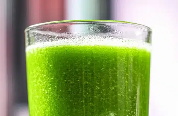 Suco verde matinal naturalmente fresco com frutas e vegetais em um copo.
