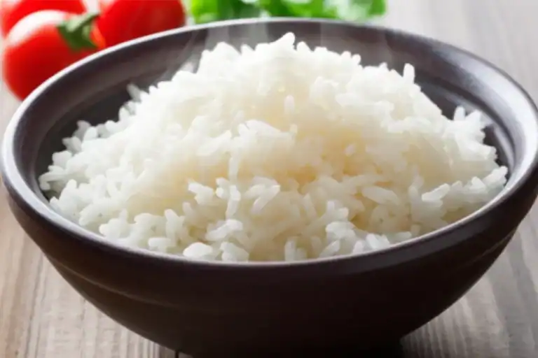 Uma tigela de arroz soltinho perfeito, branco e fumegante, pronto para servir, com grãos separados.